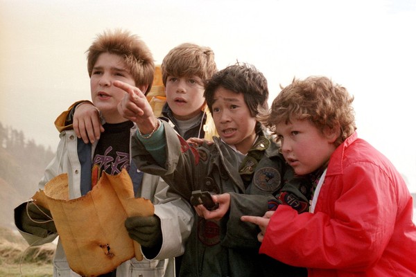 Corey Feldman, Sean Astin, Jonathan Ke Quan e Jeff Cohen buscam o tesouro do pirata Willy Caolho (Foto: Divulgação)