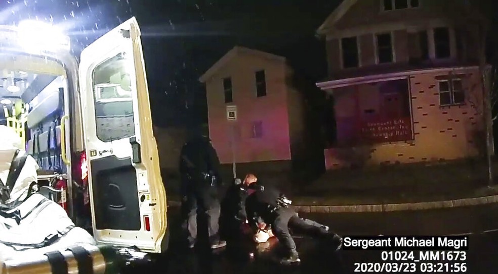 Policiais ainda seguram Daniel Prude, um homem negro, no chão mesmo com a presença de uma ambulância — Foto: Rochester Police via Roth and Roth LLP via AP