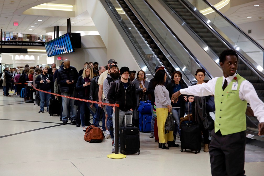 FuncionÃ¡rio organiza fila em aeroporto de Atlanta, nos EUA, onde ausÃªncia de servidores por causa do 'shutdown' causou atrasos â Foto: Elijah Nouvelage/Reuters