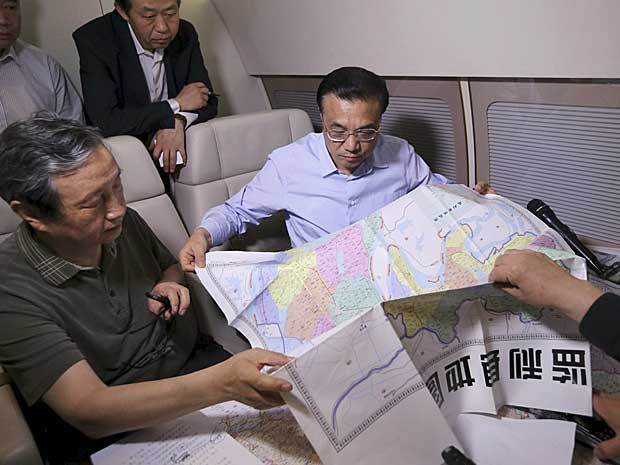 Premiê chinês, Li Keqiang, discute plano de resgate com um mapa nas mãos (Foto: Reuters)