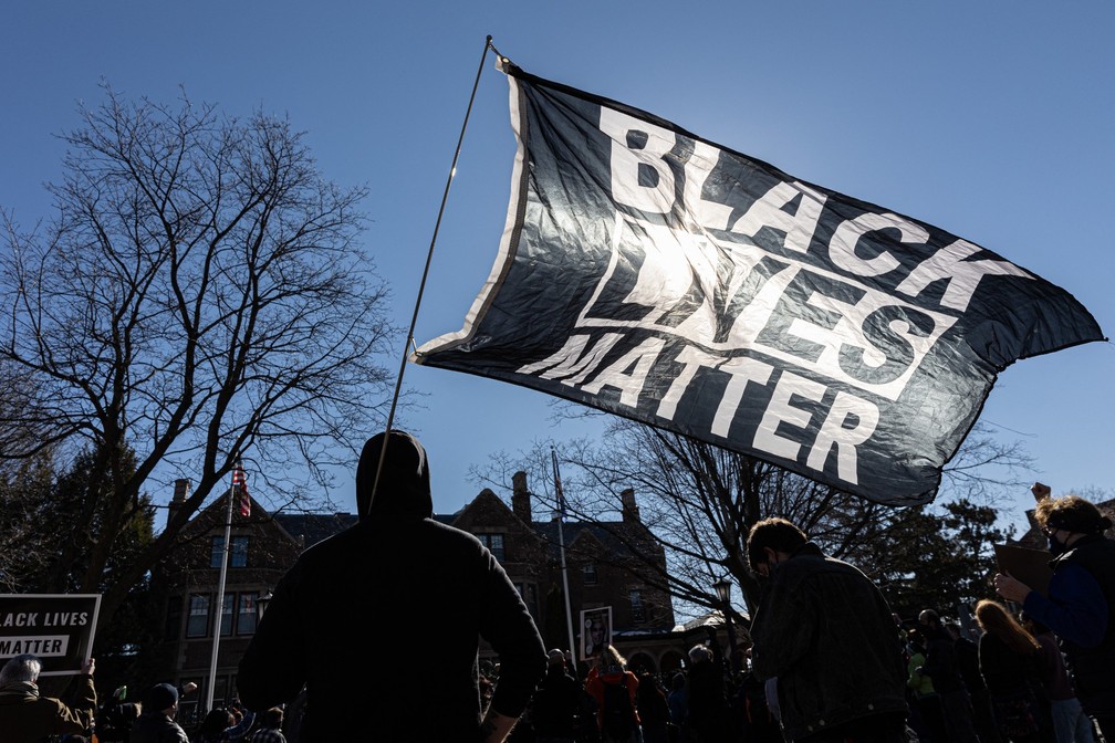 Manifestantes erguem a bandeira do Black Lives Matter durante protesto por justiça para George Floyd, em St. Paul, Minnesota — Foto: Kerem Yucel/AFP