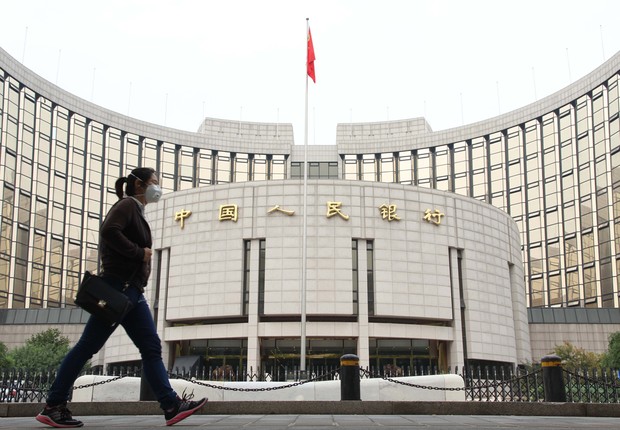 Transeunte caminha diante da sede do Banco do Povo da China, o banco central chinês (Foto: Teh Eng Koon/AFP/Getty Images)