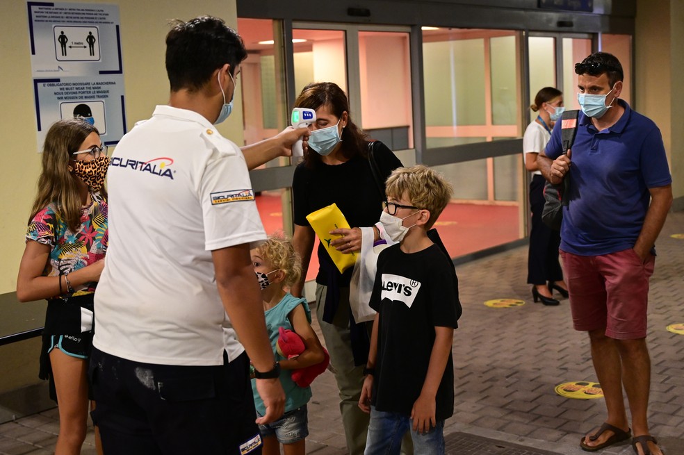 Passageiros de cruzeiro turístico têm a temperatura aferida no porto italiano de Gênova após retorno das operações em meio a pandemia — Foto: Miguel Medina/AFP