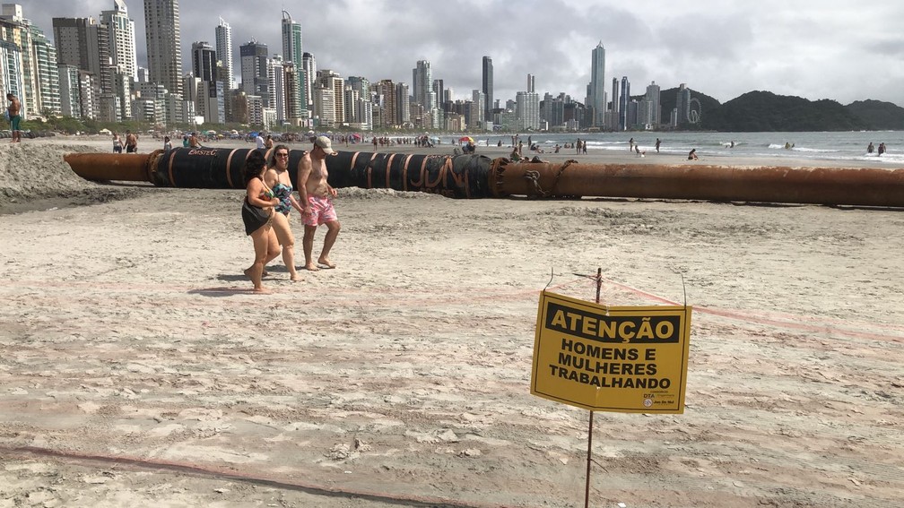 Banhistas caminham na área interditada da Praia Central, em Balneário Camboriú, nesta terça-feira (2) — Foto: Fabiano Correia/NSC TV