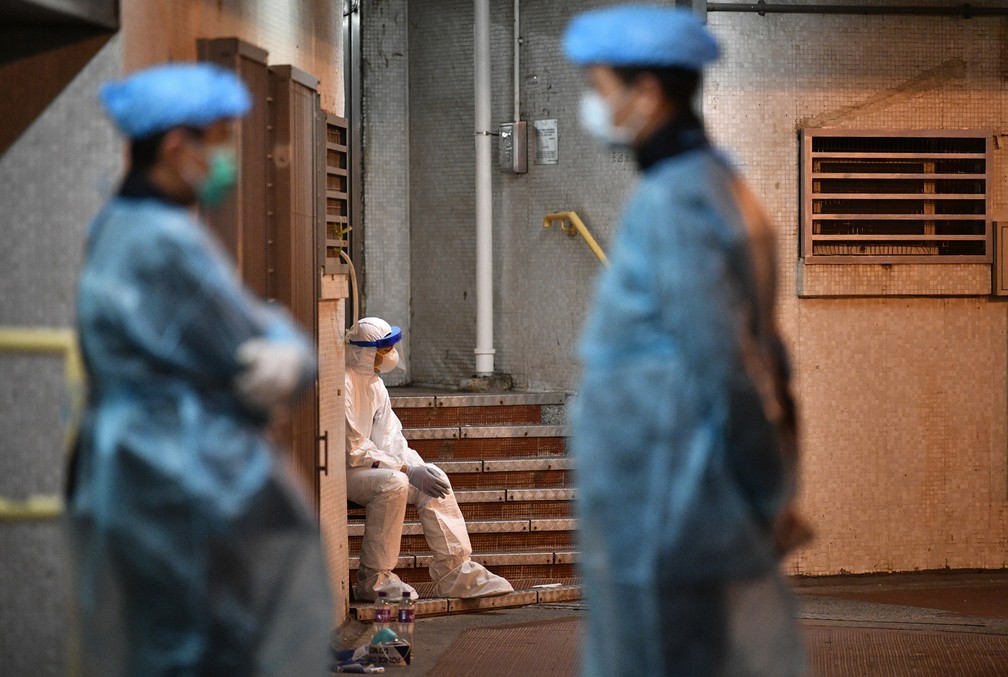 Equipe médica acompanha evacuação de prédio em Hong Kong onde foram encontrados dois casos suspeitos de coronavírus — Foto: Anthony Wallace/AFP