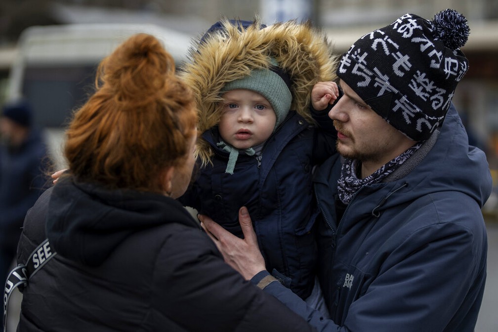 Vlad abraça o filho, Danya, nos braços da mãe, Tatiana — Foto: AP Photo/Emilio Morenatti