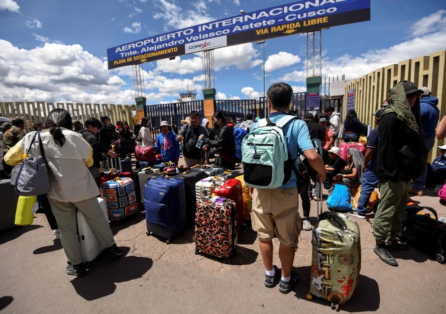 Viajantes fazem fila do lado de fora do aeroporto internacional de Cusco, no Peru, esperando sua vez de embarcar em seus voos