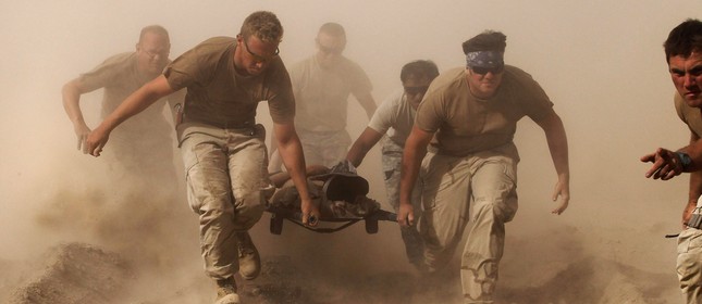 Membros da Marinha dos Estados Unidos carregam um camarada ferido por explosão em helicóptero de evacuação médica na província de Kandahar, no Sul do Afeganistão