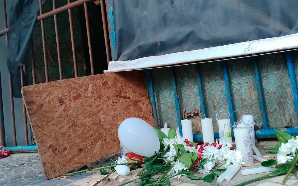 Flores e velas também foram colocadas na entrada do Terminal em Mar Grande, de onde embarcação que virou saiu (Foto: Juliana Almirante/ G1)