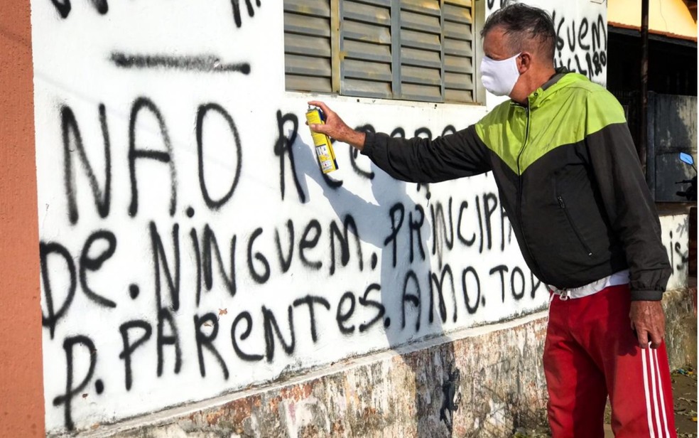 Filho picha muro de casa para afastar visitas e proteger mãe idosa durante a pandemia, em Bela Vista de Goiás — Foto: John William/TV Anhanguera