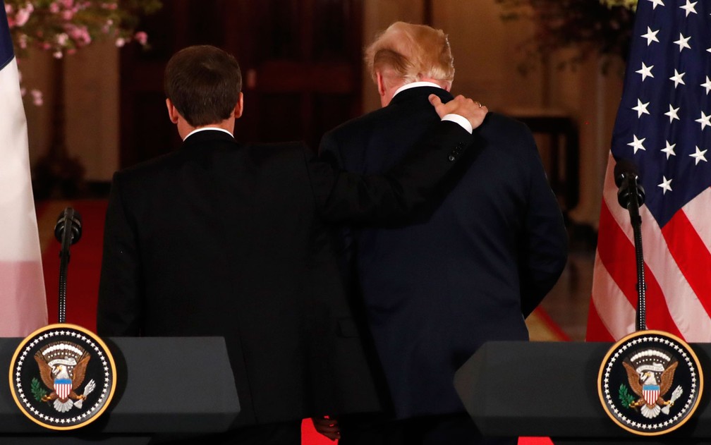 O presidente francês Emmanuel Macron coloca a mão no ombro do presidente americano Donald Trump após coletiva de imprensa conjunta na Casa Branca, na terça-feira (24) (Foto: Reuters/Jonathan Ernst)