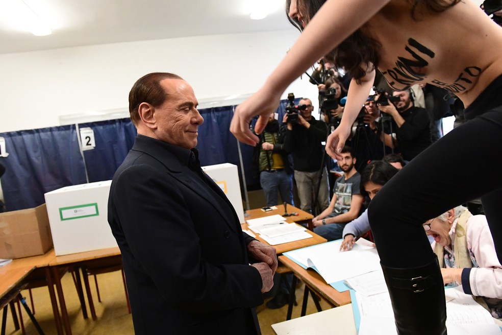 Silvio Berlusconi A� alvo de protesto de ativista feminina durante votaA�A?o na ItA?lia (Foto: Miguel Medina/AFP)
