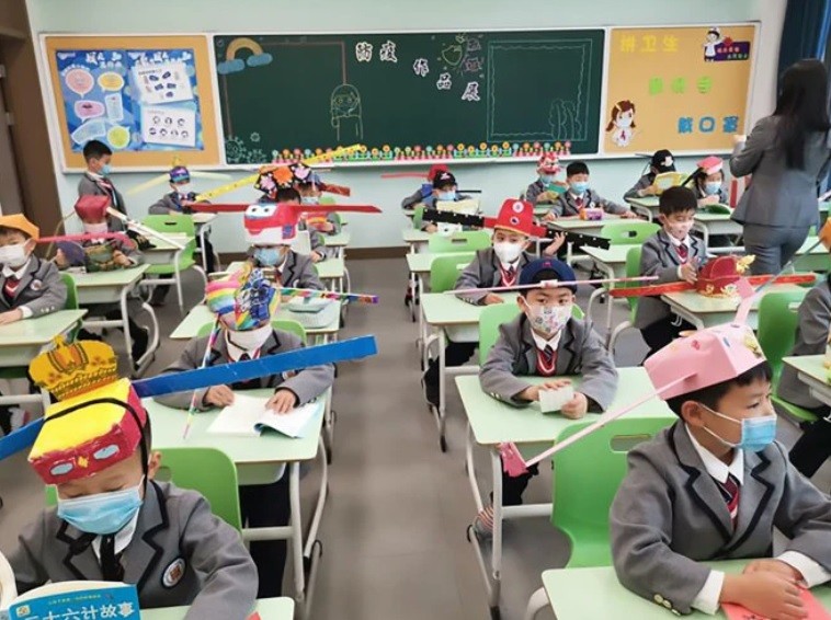 Crianças usam chapéu com régua para respeitar distância (Foto: Reprodução )