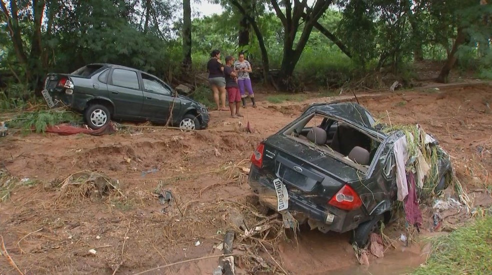 Dois dos três carros que foram arrastados pela enxurradas ficaram destruídos — Foto: TV TEM/Reprodução