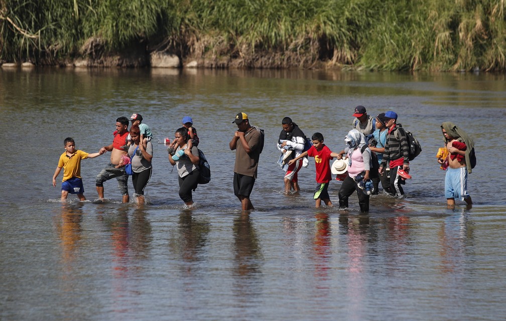 Migrantes cruzam rio a pé para chegar ao México a partir da Guatemala nesta terça-feira (21) — Foto: Moises Castillo/AP Photo