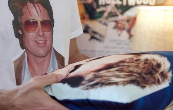 O ator George Clooney vestido com uma camisa com o rosto de Brad Pitt e segurando uma almofada em homenagem ao amigo (Foto: Reprodução)