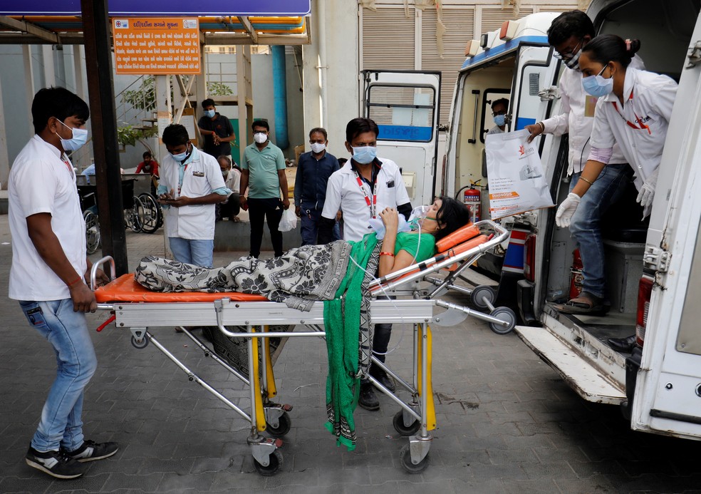 Paciente com máscara de oxigênio é levado para dentro de hospital para Covid-19 em Ahmedabad, na Índia, nesta quarta (21) — Foto: Amit Dave/Reuters