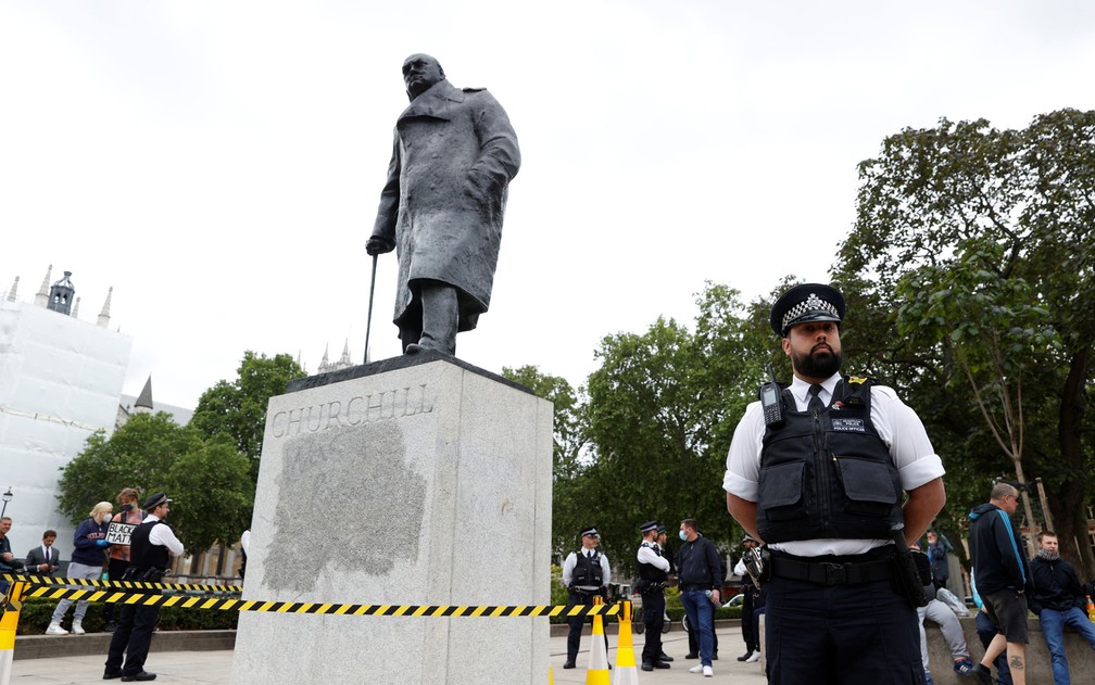Policiais vigiam a estátua de Sir Winston Churchill na Parliament Square, em Londres, na segunda-feira (8)  — Foto: Reuters/John Sibley 