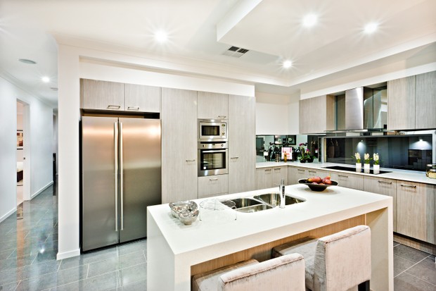 Modern kitchen counter top with a fridge and pantry giving a shiny look the house interior with flashing lights over the tile floor hallway (Foto: Getty Images/iStockphoto)