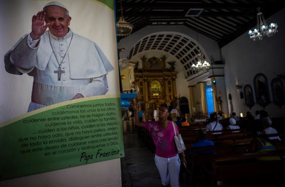 Mulher reza próxima a imagem do papa Francisco em uma igreja em  Regla, em Cuba, o pontífice vai visitar a ilha em setembro (Foto: Ramon Espinosa/AP Photo)