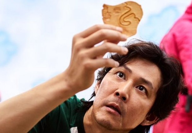 Seong Gi-hun, um dos personagens principais de 'Round 6', segura uma dalgona (Foto: Netflix via BBC News)