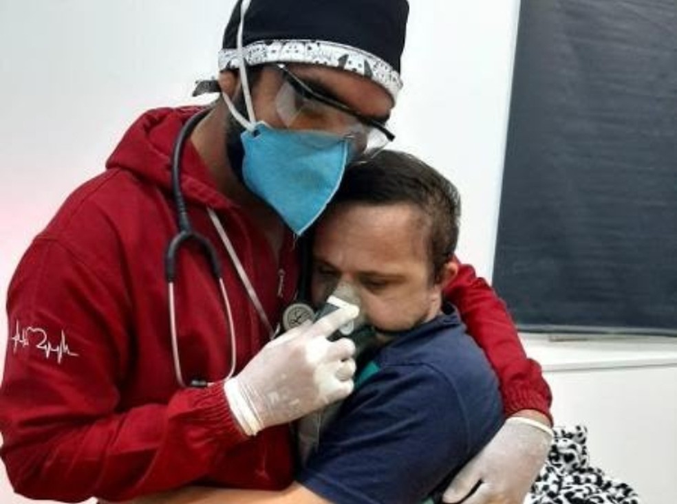 Enfermeiro abraçou paciente com síndrome de Down para tranquilizá-lo enquanto ele recebia oxigênio. — Foto: Arquivo Pessoal