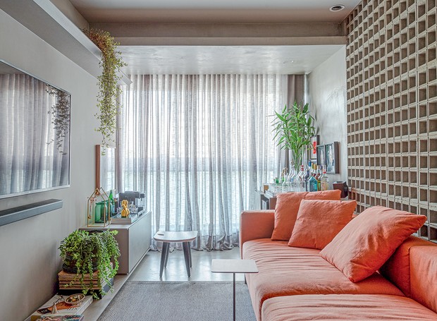 Na sala de estar, a banqueta Sonia, de Sergio Rodrigues, traz versatilidade e compõe o mobiliário com sofá e minibar. Os móveis do apartamento são da Home Design (Foto: Gabriela Daltro / Divulgação)