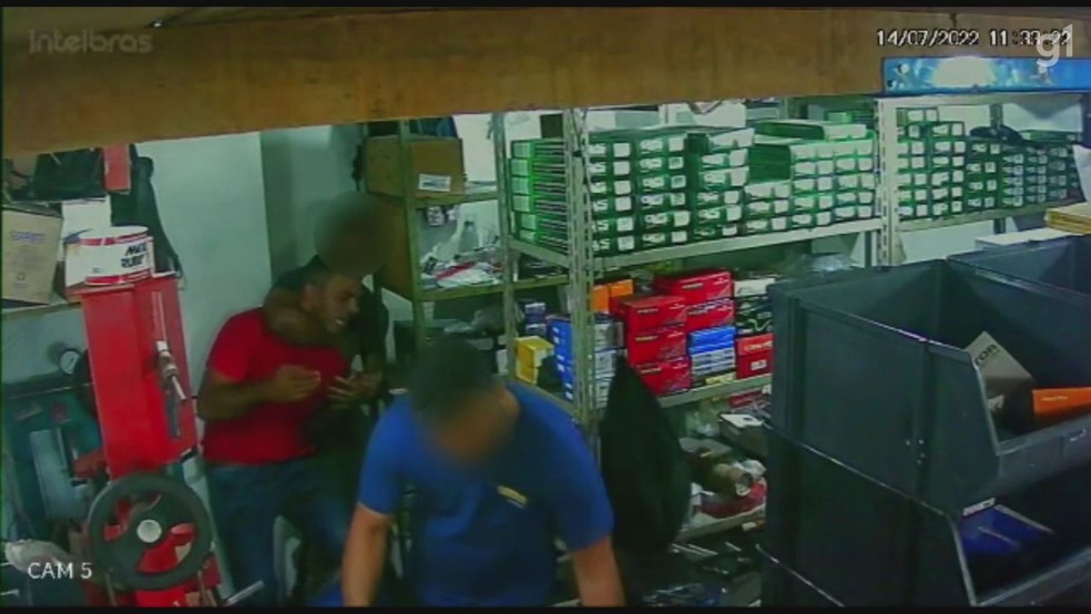 O homem de vermelho invadiu a oficina e tentou matar o companheiro da ex dele, que na foto aparece aplicando um mata le&atilde;o no agressor &mdash; Foto: Reprodu&ccedil;&atilde;o
