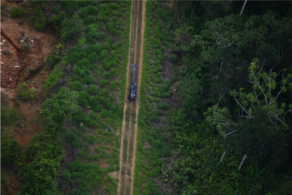 Helicóptero em outra pista clandestina no alto Catrimani. Ao lado esquerdo, há cerca de 4,8 hectares degradados. — Foto: Divulgação/HAY.