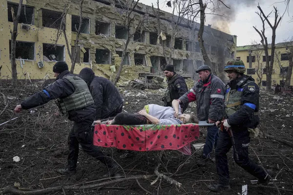 Em uma das imagens mais marcantes da guerra, grávida atingida na virilha é levada em maca diante de cenário devastador após bombardeio a uma maternidade em Mariupol, em março de 2023.Ela morreu horas depois.  — Foto: Evgeniy Maloletka/AP