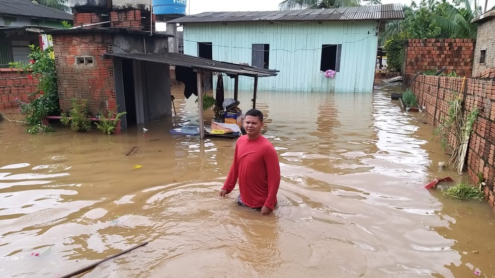 Autônomo Eliel Freitas tenta salvar móveis na casa da mãe no bairro Raimundo Melo, em Rio Branco — Foto: Eldérico Silva/Rede Amazônica