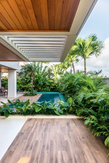O escritório Matheus Duarte Arquitetura desenhou uma piscina em "L" abraçada por espécies de pouca manutenção, com folhagens exuberantes, escolhidas por Cíntia Senna Paisagismo. No contorno, barba-de-serpente, areca-bambu, alpínias vermelhas, entre outras