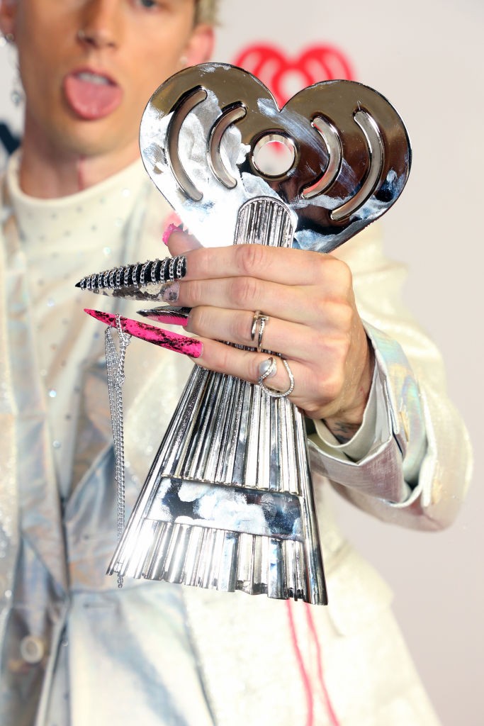 LOS ANGELES, CALIFORNIA - MAY 27: (EDITORIAL USE ONLY) Machine Gun Kelly, winner of the Alternative Rock Album of the Year award for 'Tickets To My Downfall,' trophy, manicure/nails, rings, and fashion details, attends the 2021 iHeartRadio Music Awards at (Foto: Getty Images for iHeartMedia)