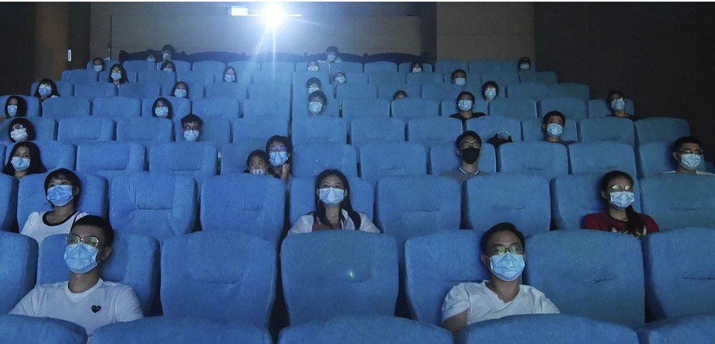 Público usa máscara e respeita distanciamento enquanto assiste a filme em um cinema recém-reaberto em Hangzhou, na província de Zhejiang, no leste da China, nesta segunda-feira (20) — Foto: Chinatopix via AP