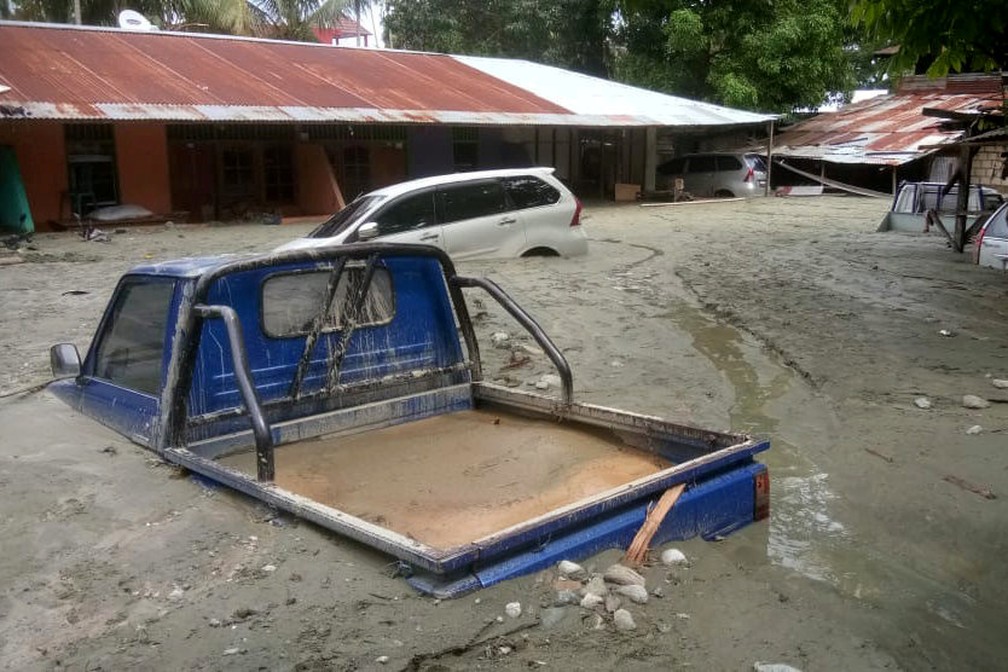 Carro submerso em inundação na Papua, na Indonésia — Foto: Gusti Tanati/Antara Foto via Reuters