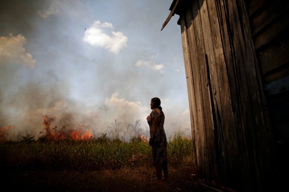 Incêndios na Amazônia: Moradora olha enquanto fogo se aproxima de sua casa perto de Porto Velho, no dia 16 de agosto. — Foto: Ueslei Marcelino/Reuters