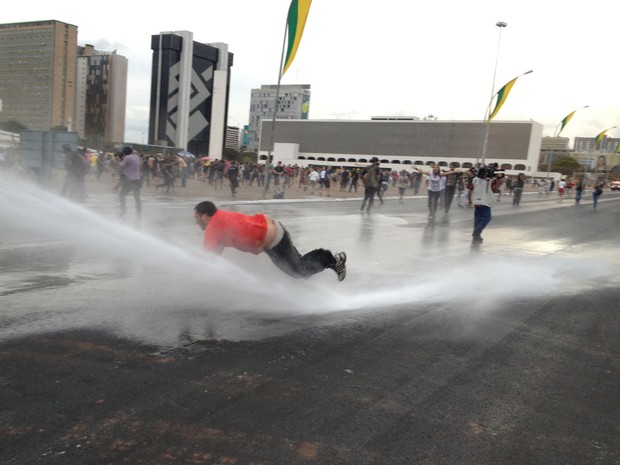 Manifestante cai ao ser atingido por jato d'água em Brasília (Foto: Felipe Neri/G1)