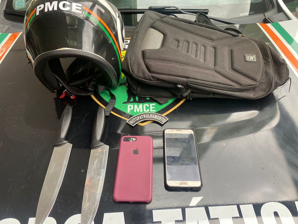 Duas facas, uma bolsa e celulares foram apreendidos com as suspeitas do assalto a ônibus em Fortaleza — Foto: Polícia Militar