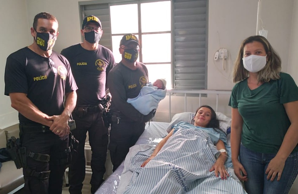 Policiais aparecem com mãe e recém-nascido após parto realizado durante bloqueio policial em MS — Foto: DOF/Divulgação