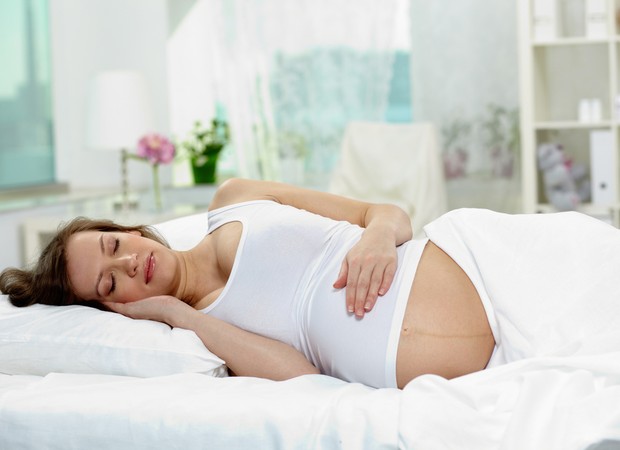 Mulher grávida dormindo com postura correta (Foto: Shutterstock)
