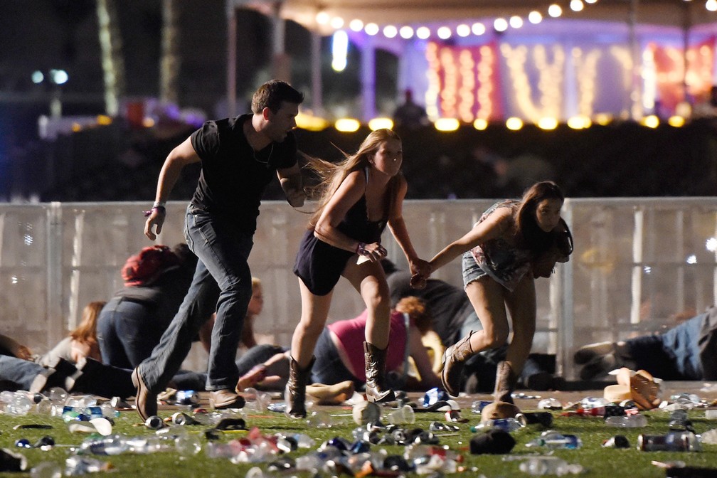 Pessoas correm para deixar o local do festival de música country onde um atirador disparou sobre uma multidão em Las Vegas, nos EUA (Foto: David Becker/Getty Images/AFP)