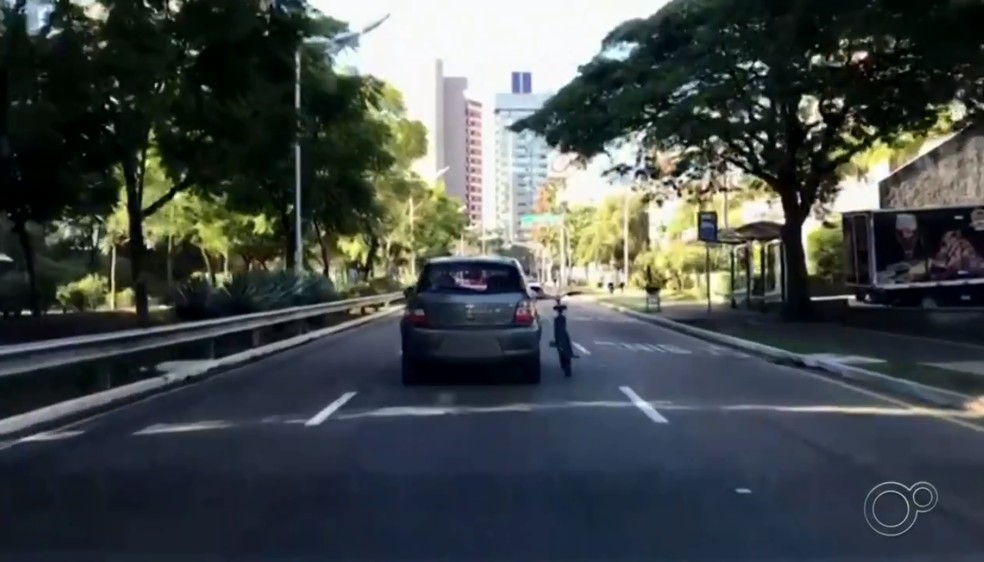 Homem &eacute; flagrado carregando bicicleta do lado de fora de carro em movimento em Jundia&iacute; &mdash; Foto: Reprodu&ccedil;&atilde;o/TV TEM