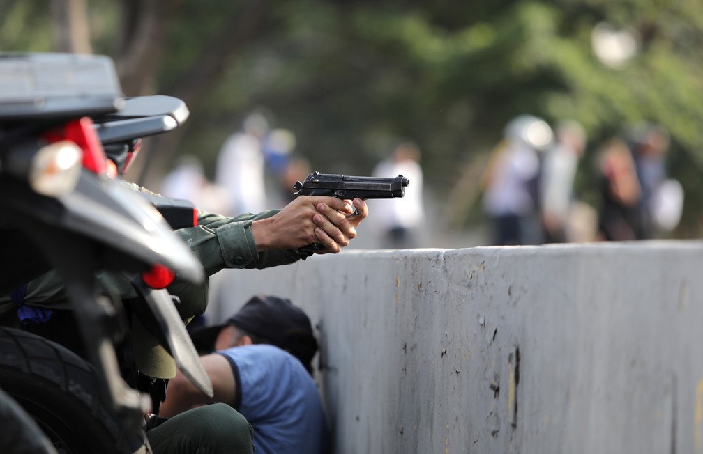Um  militar aponta uma arma perto da base aérea Generalisimo Francisco de Miranda, conhecida como 'La Carlota', em Caracas — Foto: Manaure Quintero/Reuters