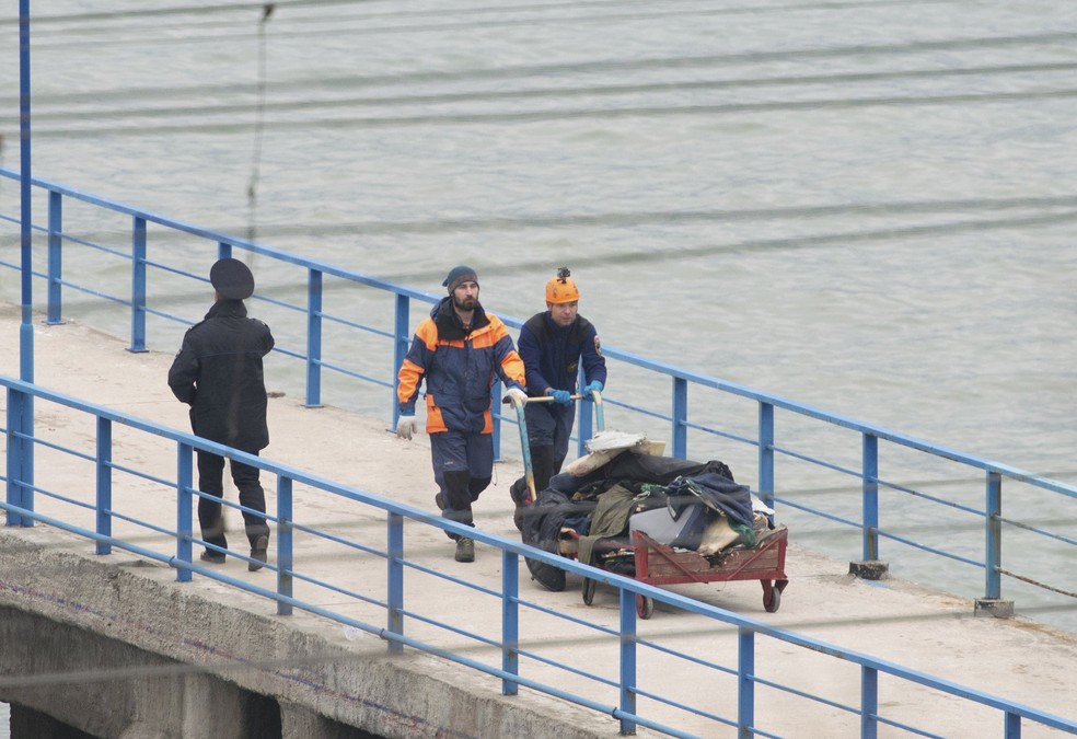 Equipe de emergência da Rússia transporta restos do avião militar russo que caiu no Mar Negro na noite deste domingo  (Foto:  REUTERS/Yevgeny Reutov )