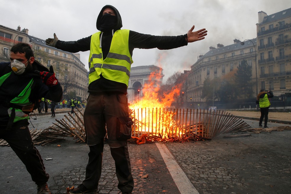 Manifestantes fazem barricada na avenida Champs-Élysées, em Paris, neste sábado (1º)  — Foto: Geoffroy Van Der Hasselt / AFP