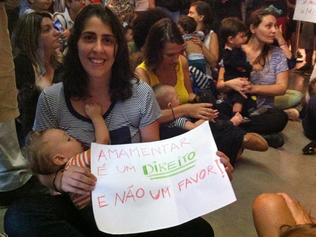 A produtora cultura Flora Assumpção, de 31 anos, segura cartaz durante mamaço no MIS, em SP, neste domingo (Foto: G1)