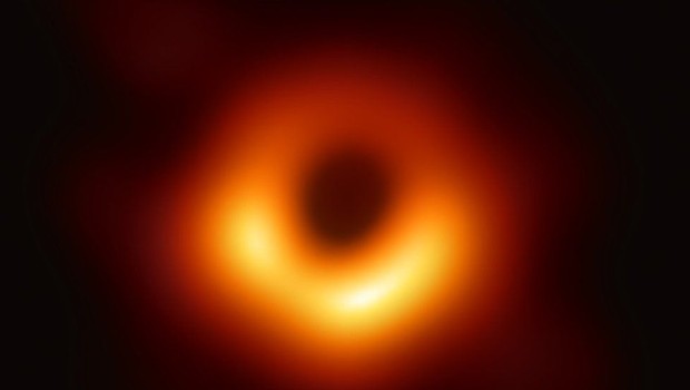 A primeira imagem da histÃ³ria de um buraco negro: ele estÃ¡ cercado pelo brilho de gases atraÃ­dos pela gravidade (Foto: EHT COLLABORATION, via BBC News Brasil)