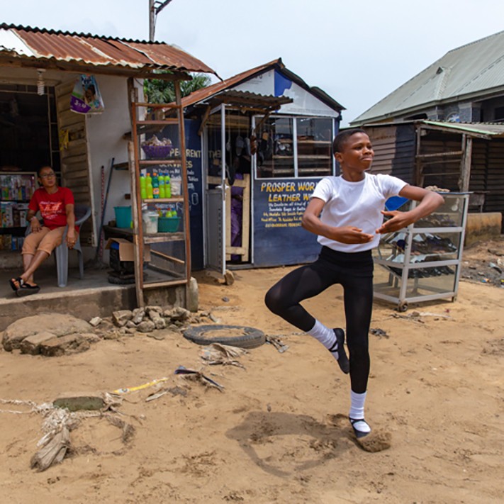 A student of the Leap of Dance Academy, Anthony Madu (R), performs a ballet dance routine in front of his mother's shop in Okelola street in Ajangbadi, Lagos, on July 3, 2020. - The Leap of Dance Academy is a ballet school in a poor district of sprawling  (Foto: AFP via Getty Images)