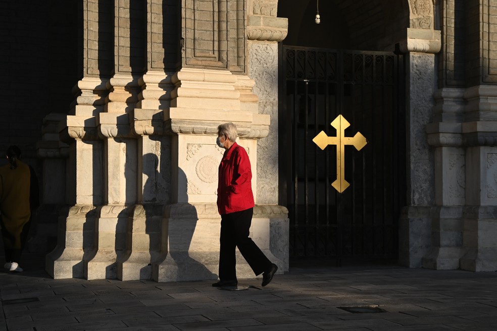 Uma mulher passa pela Igreja Católica Wangfujing, em Pequim, nesta quinta-feira (22) — Foto: Greg Baker/AFP