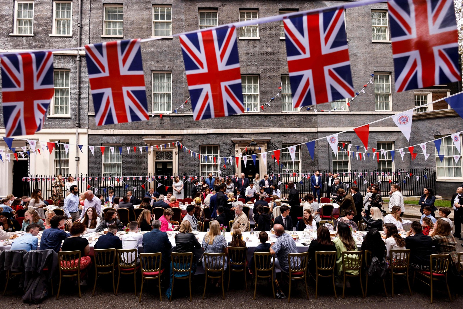 Convidados participam de um grande almoço de coroação organizado em Downing Street pelo primeiro-ministro britânico e sua esposa, em Londres — Foto: Odd ANDERSEN / AFP